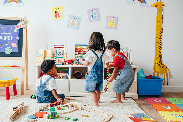 Drei Kinder spielen mit Spielzeug.